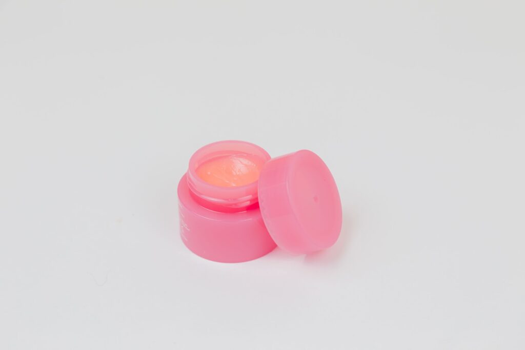 Pink jar with white, pink cream for face, hands, feet, body on a white background. The beauty. The medicine. View from above. Advertising. Place for an inscription. Decorative cosmetics.